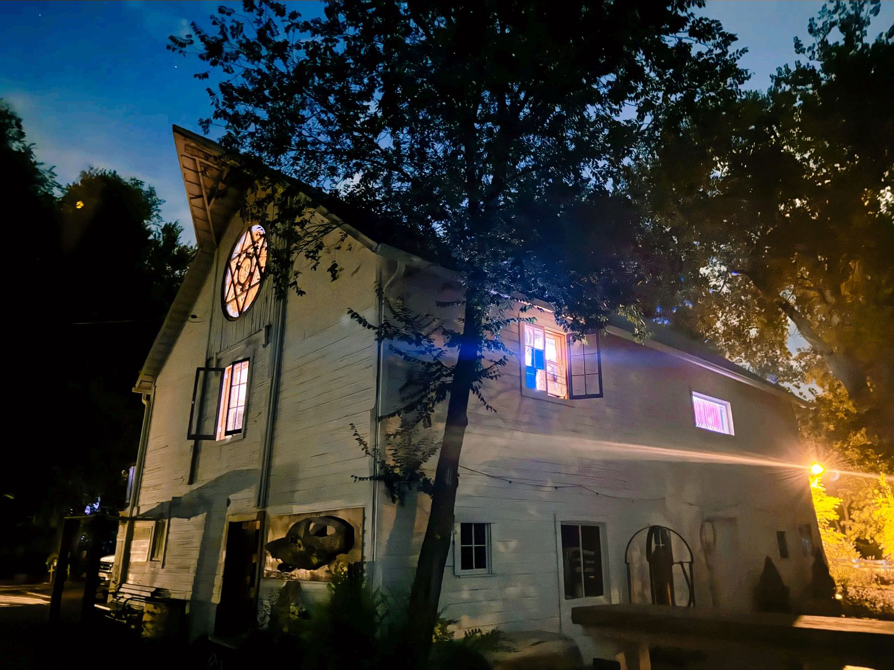 The white barn at dusk with lit windows