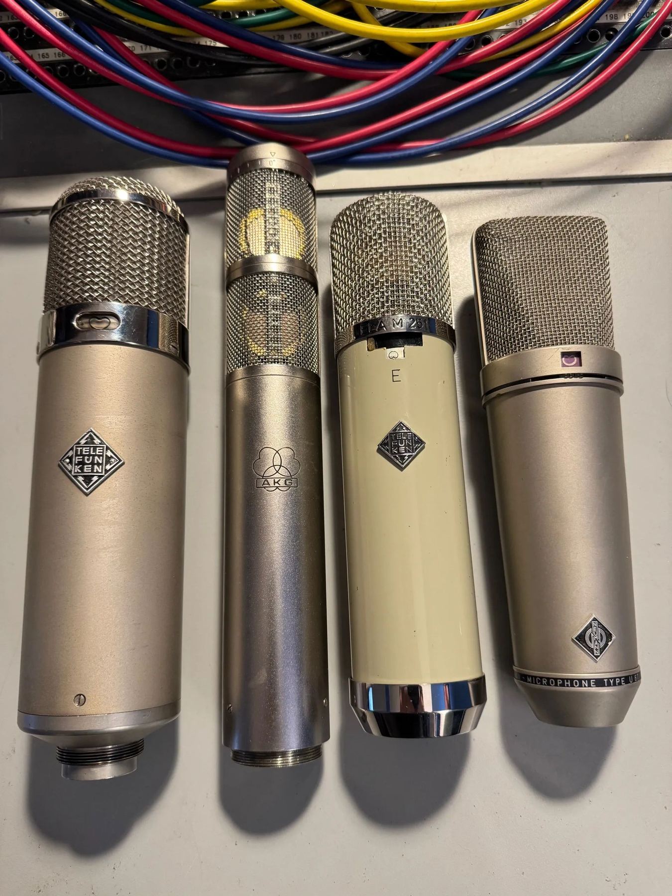 Four vintage tube microphones laid side by side