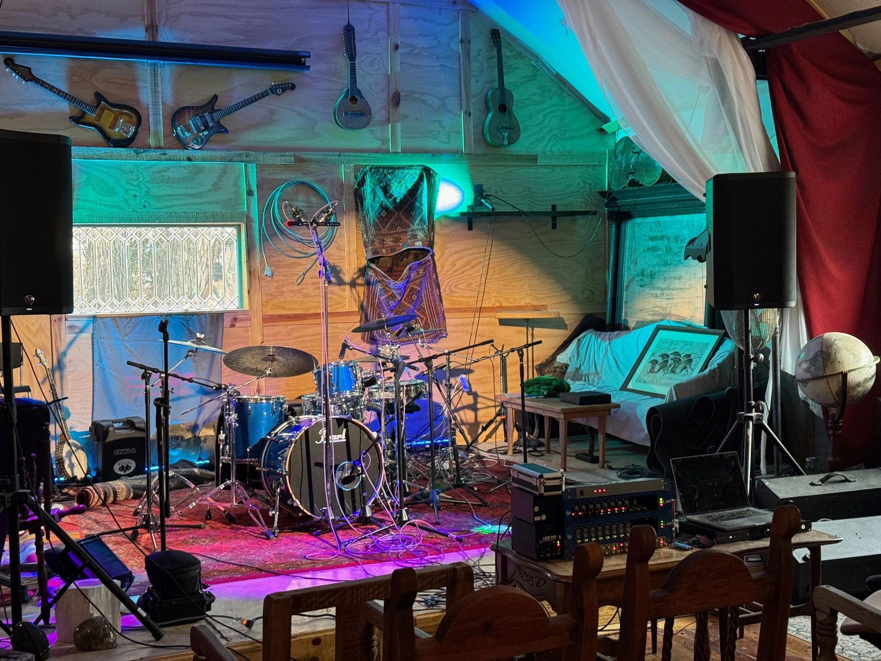 The barn stage with a band's gear set up under coloured light