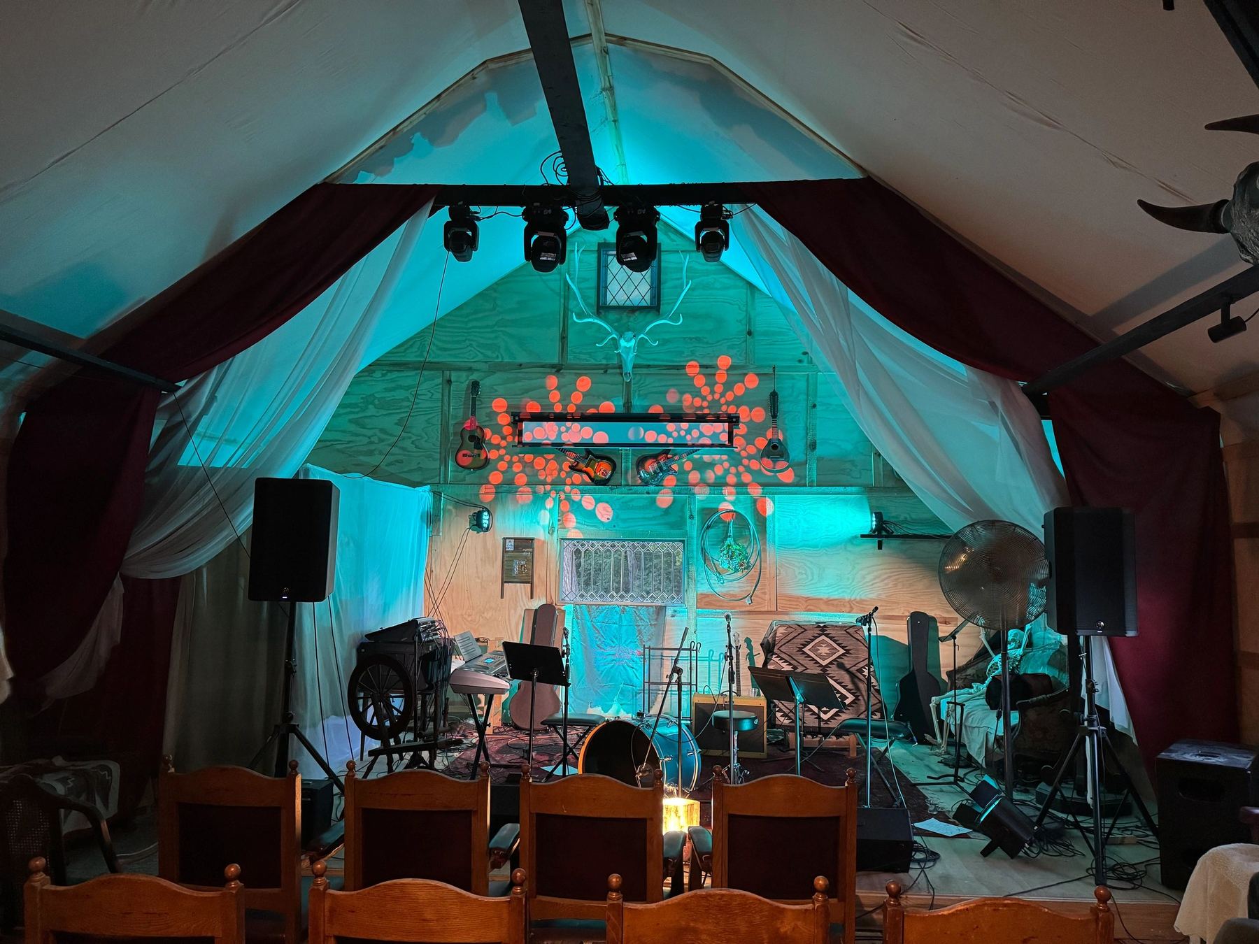 The stage lit teal with a drum kit set up